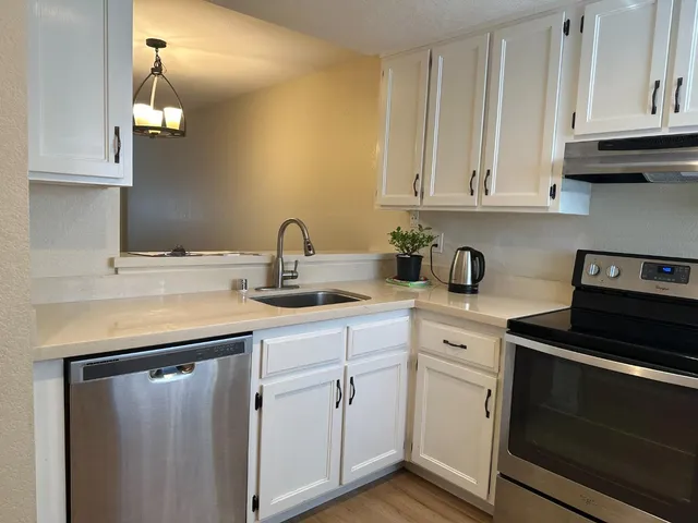 a kitchen with white cabinets and white appliances