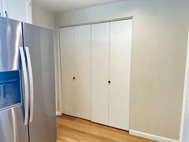 a utility room with wooden floor washer and dryer
