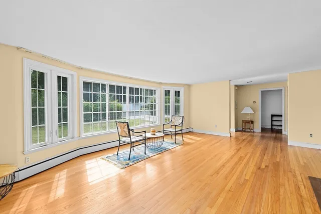 a view of a livingroom with wooden floor and furniture