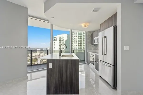 a kitchen with stainless steel appliances granite countertop a refrigerator a sink and a stove