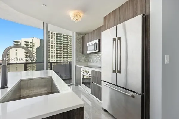 a kitchen with stainless steel appliances granite countertop a refrigerator and a sink