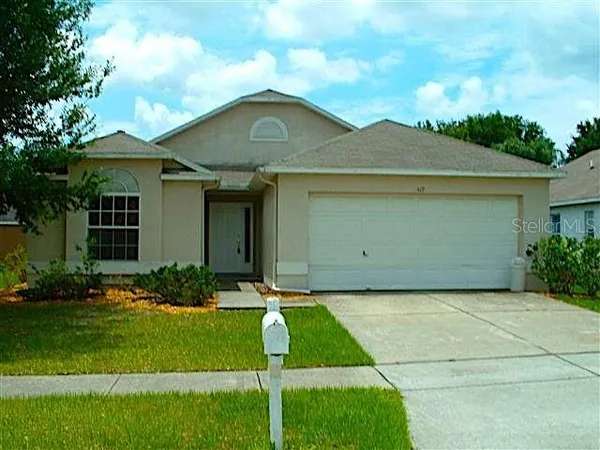 a front view of a house with a garden and plants
