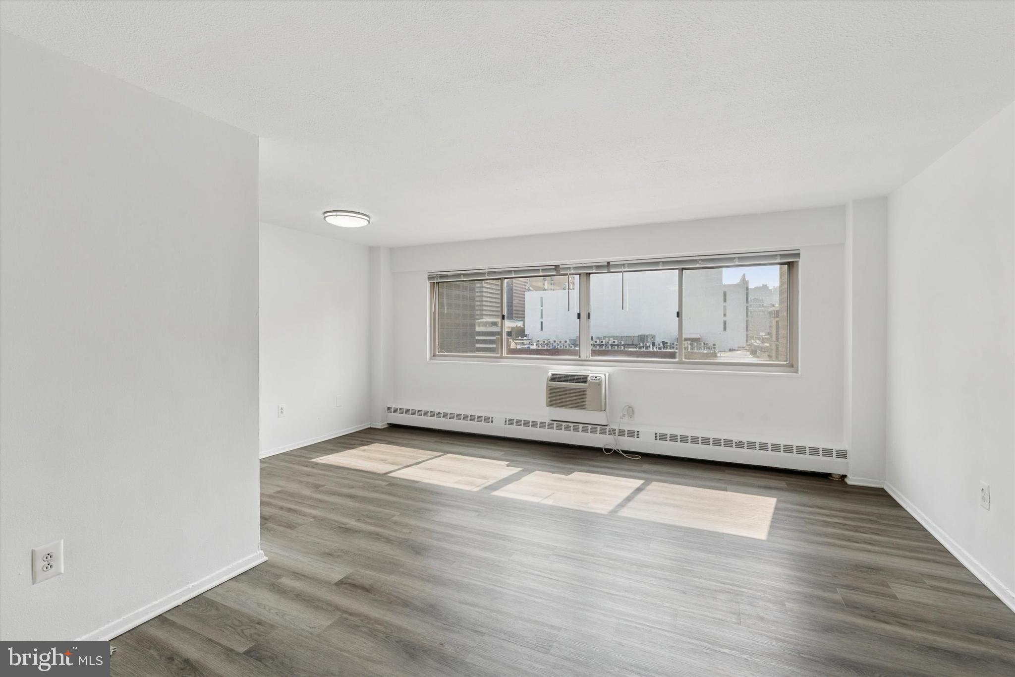 a view of a room with wooden floor and white walls