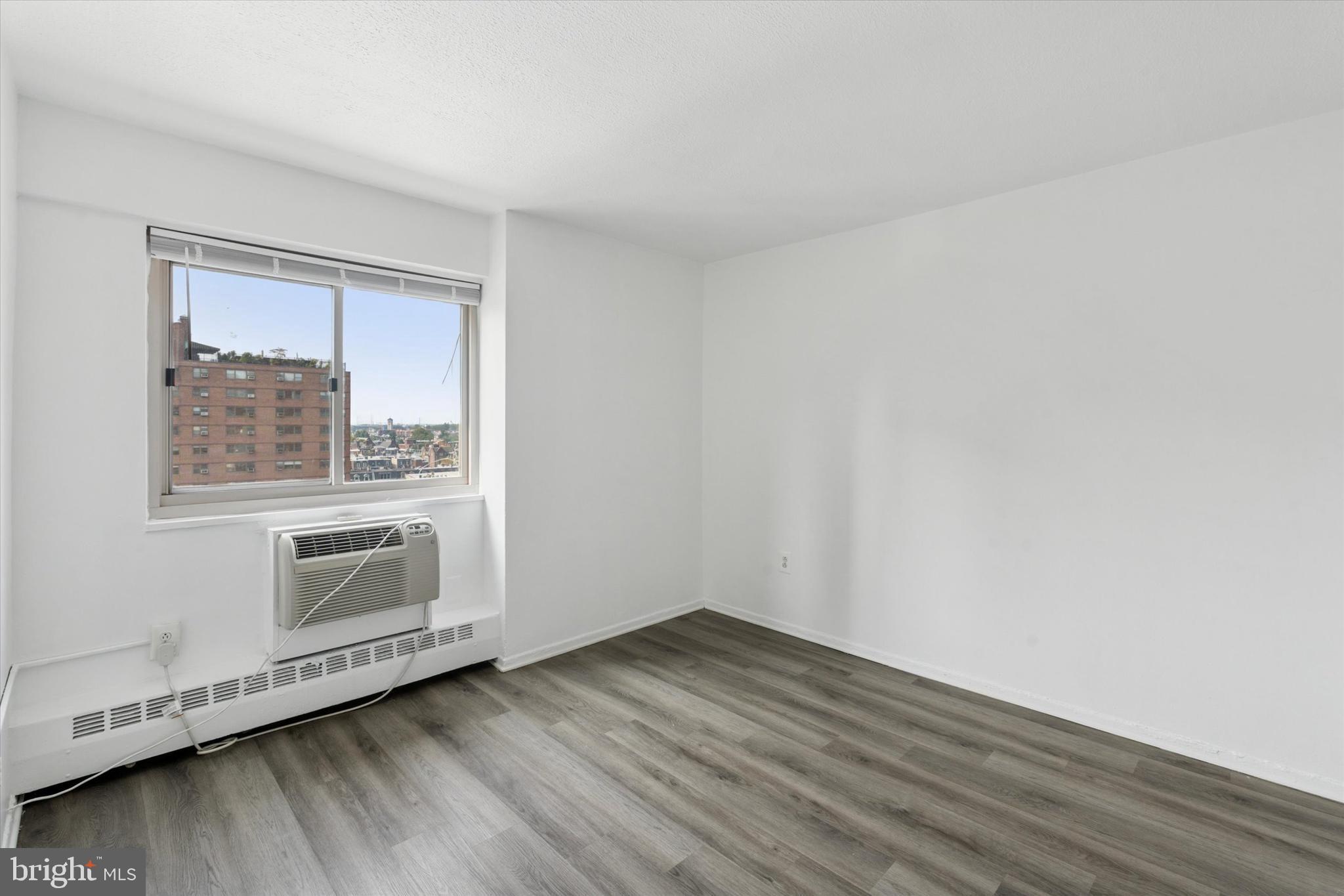 2101 Chestnut Street, Unit 1208 Philadelphia, PA 19103 - Photo 11 of 15 a view of an empty room with wooden floor and a window