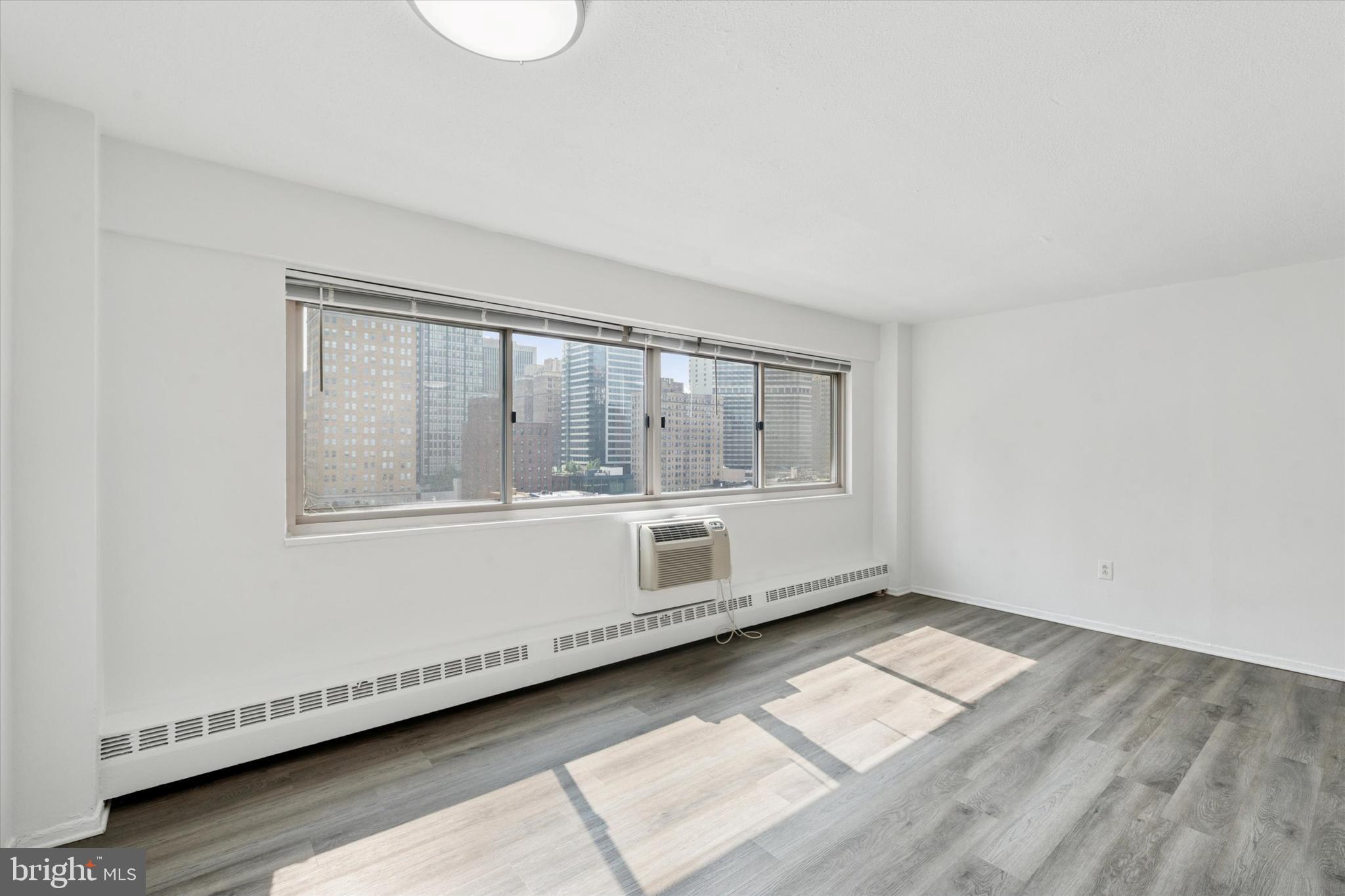 2101 Chestnut Street, Unit 1208 Philadelphia, PA 19103 - Photo 5 of 15 a big room with wooden floor and windows
