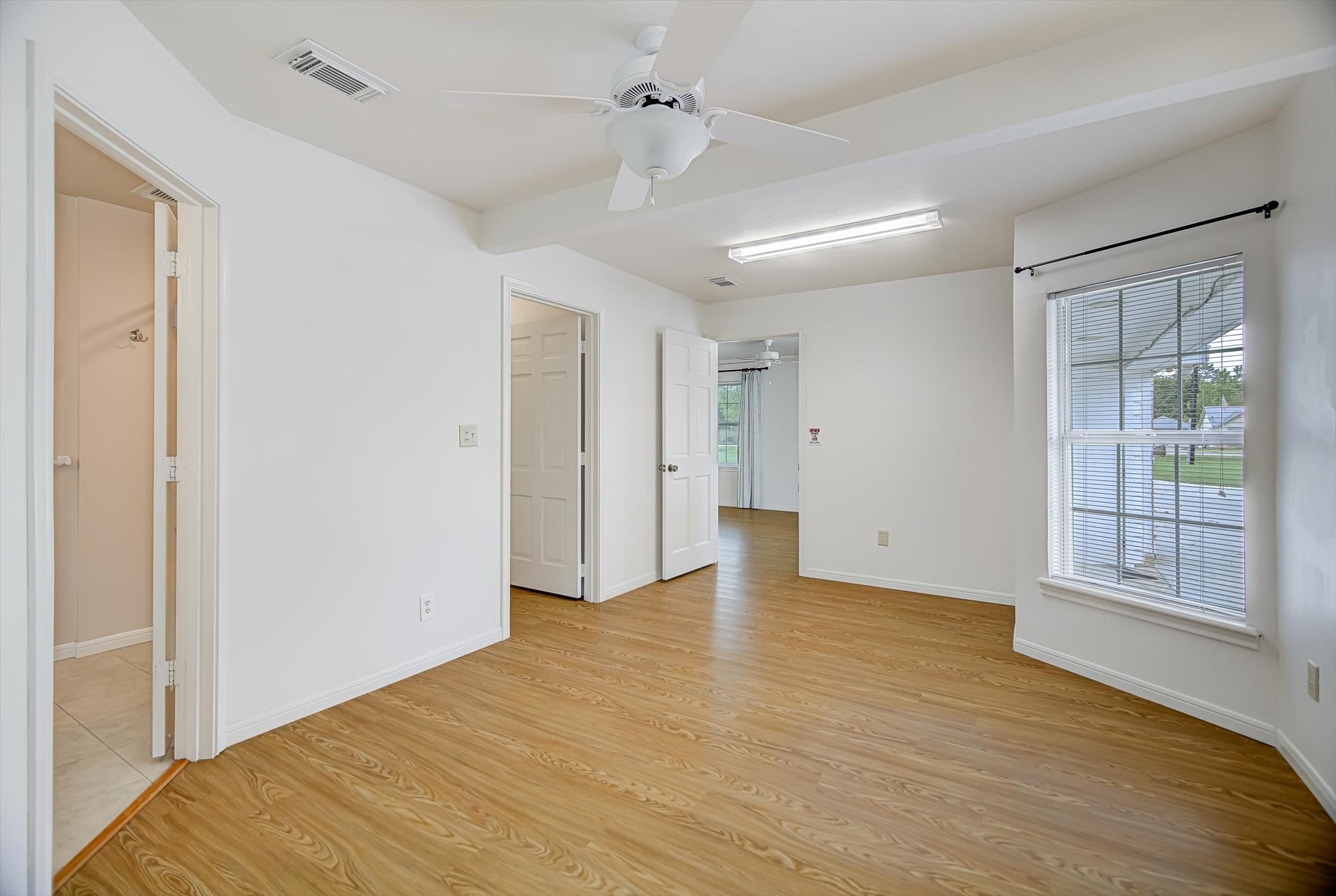 106 Woodland Road Lake Jackson, TX 77566 - Photo 21 of 46 a view of an empty room with window and wooden floor