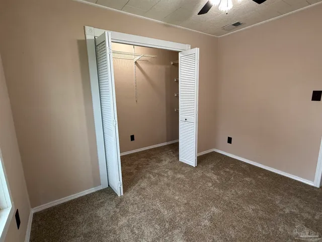 an empty room with fan and entrance