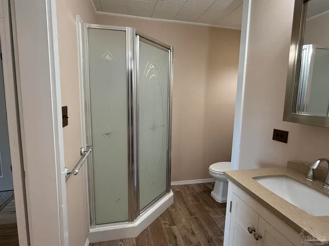 a bathroom with a granite countertop sink toilet and shower
