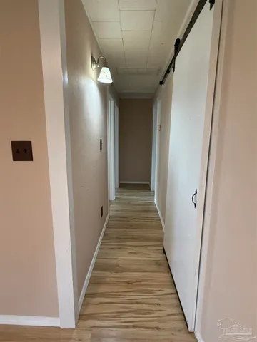 a view of a hallway with wooden floor and staircase