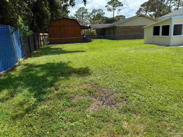 a view of a yard in front of a house with a large tree