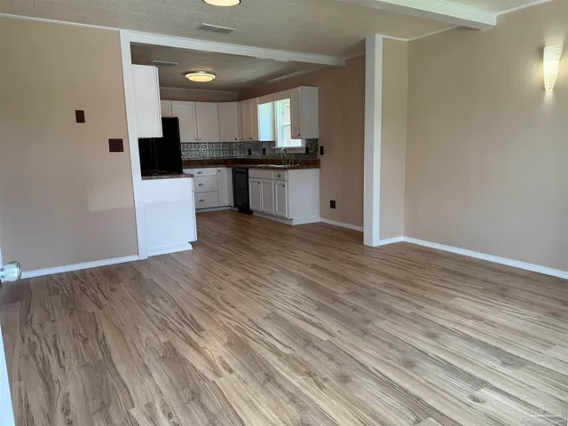 a kitchen with granite countertop a stove a sink and a refrigerator
