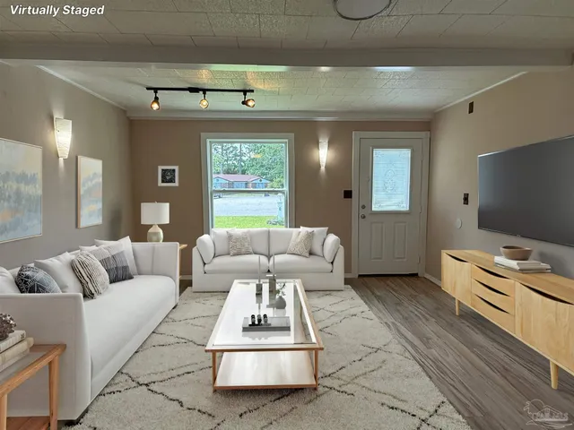 a living room with furniture a flat screen tv and a floor to ceiling window