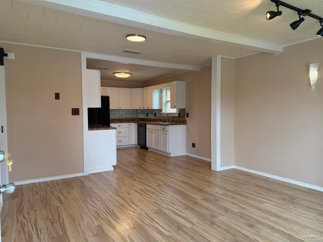 a kitchen with granite countertop a stove top oven a sink and a refrigerator