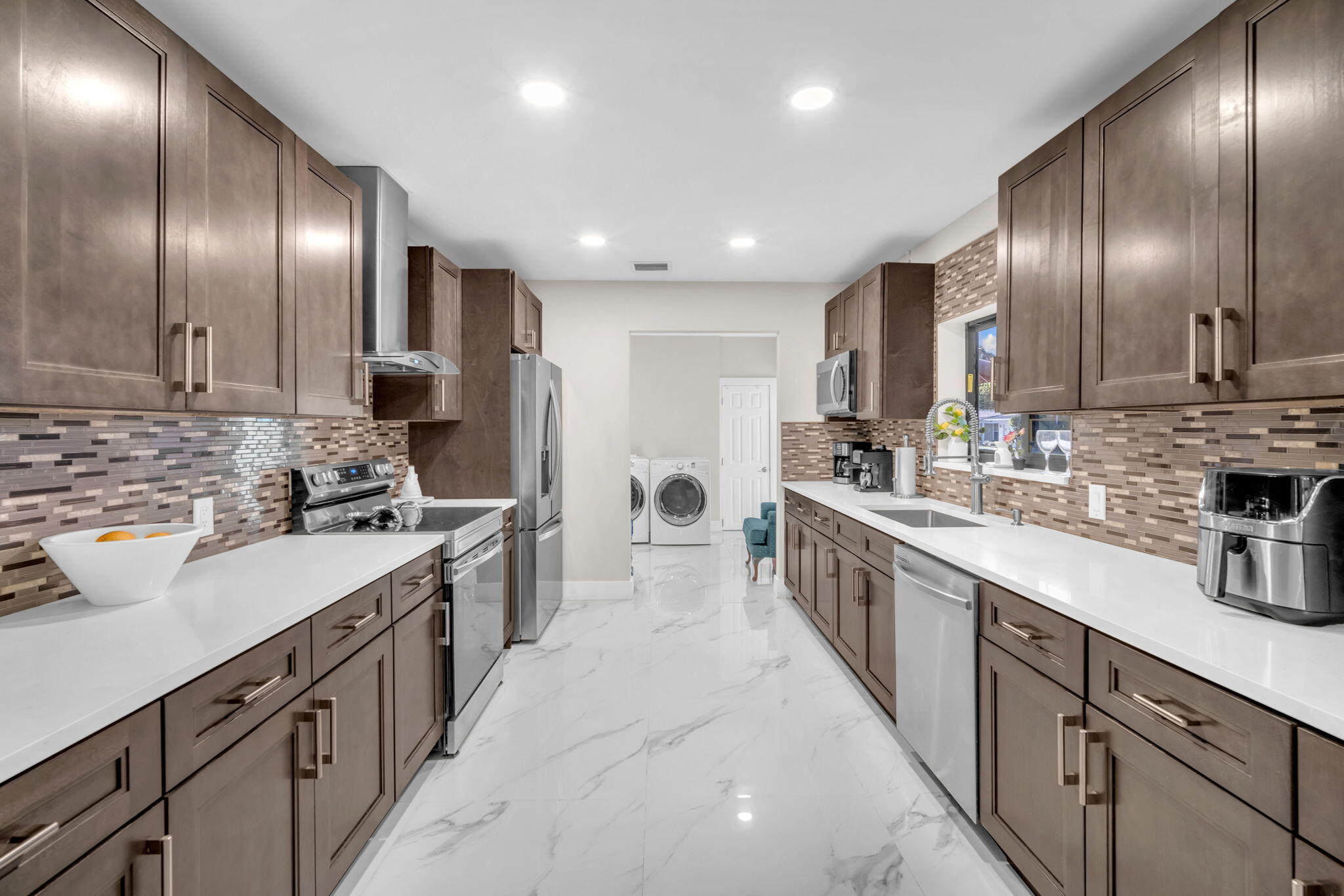 a large kitchen with stainless steel appliances lots of counter top space