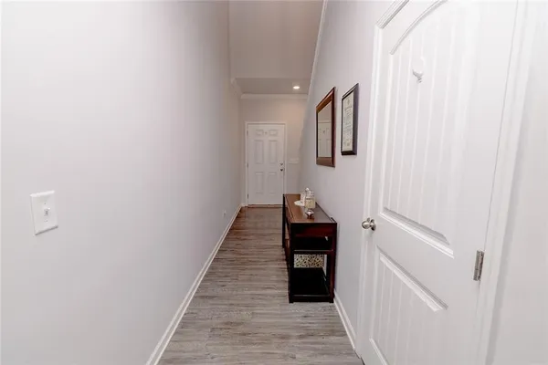 a view of a hallway with wooden floor and staircase