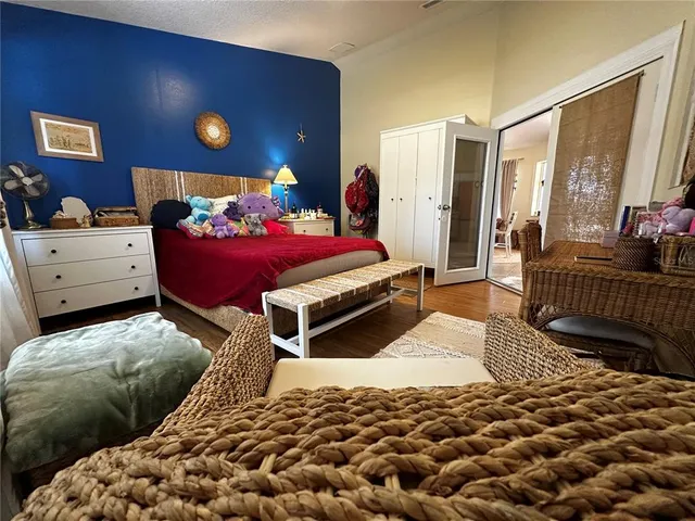 a bedroom with a bed and wooden floor