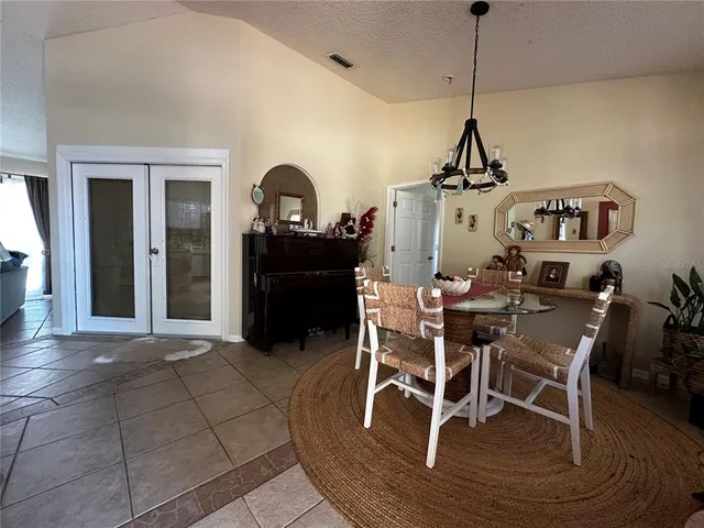 a view of a dining room and livingroom with furniture wooden floor a chandelier