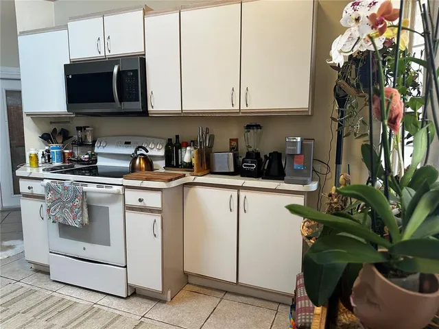 a kitchen with stainless steel appliances granite countertop a white cabinets and a stove top oven