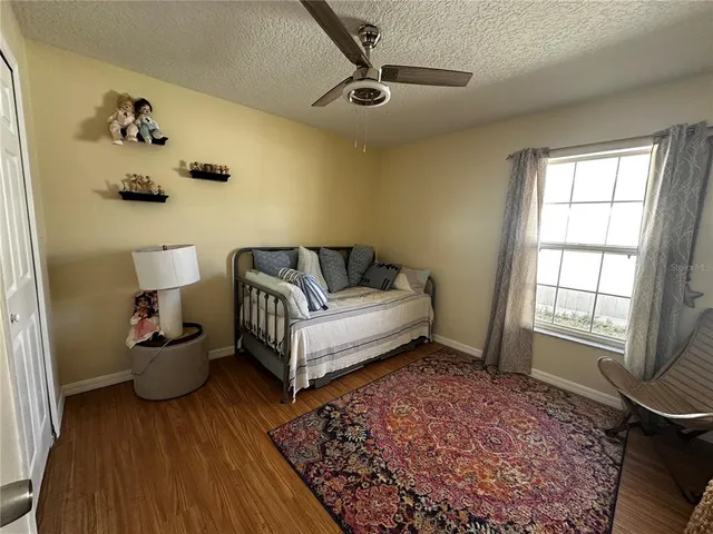 a spacious bedroom with a bed and wooden floor