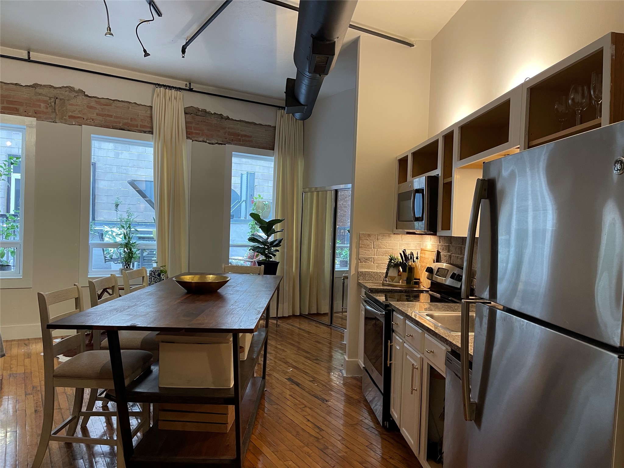705 Main Street, Unit 311 Houston, TX 77002 - Photo 9 of 23 Enjoy the views of the picturesque windows as you enter the kitchen and living space. The custom table and refrigerator and washer and dryer remains with the loft.