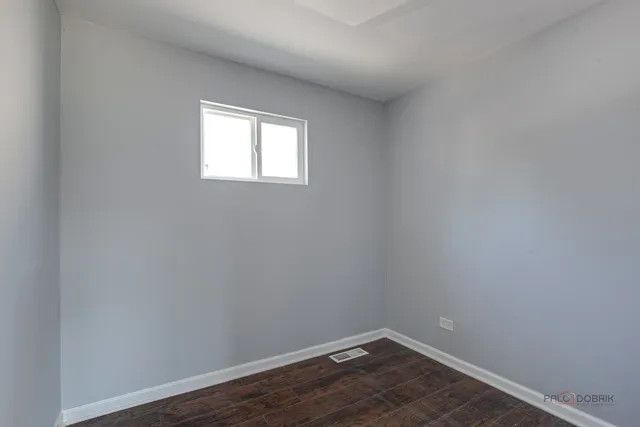 a view of a small space with wooden floor and a window