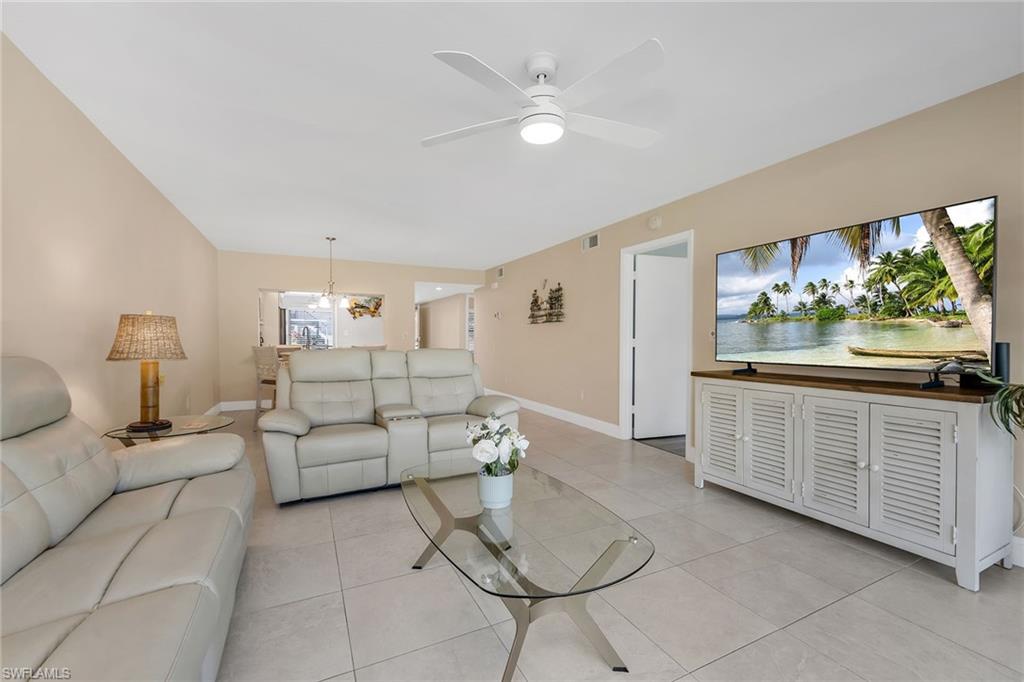 236 Pebble Beach Circle, Unit A102 Naples, FL 34113 - Photo 12 of 40 a living room with furniture and a large window