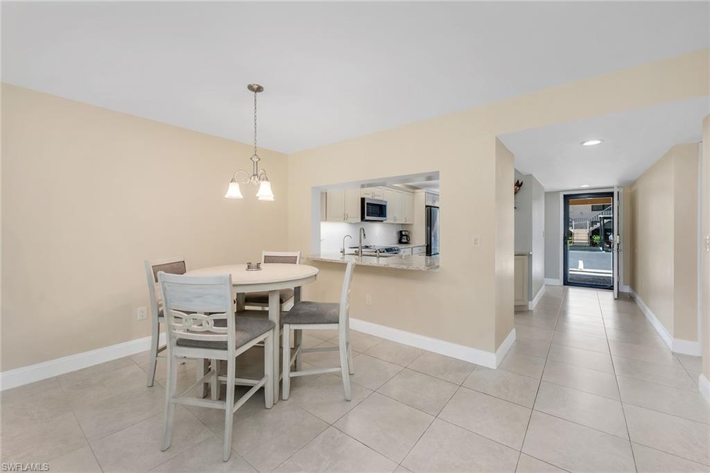 236 Pebble Beach Circle, Unit A102 Naples, FL 34113 - Photo 15 of 40 a dining room with furniture and window