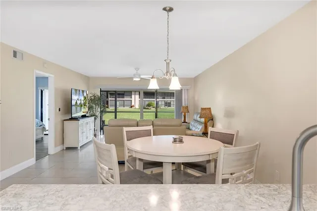 a dining room with furniture a chandelier and wooden floor