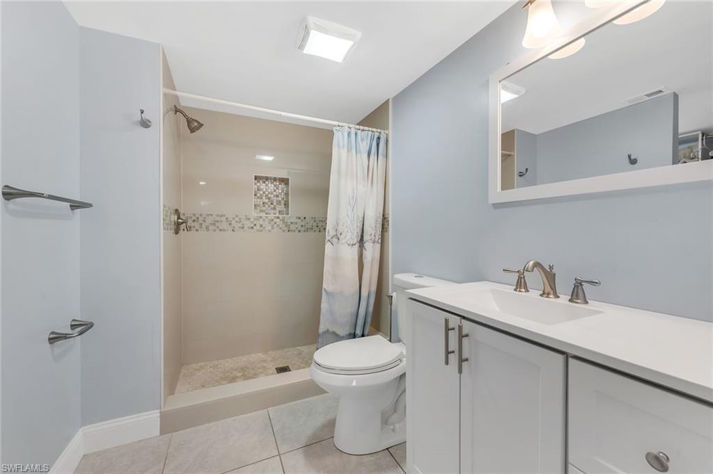 236 Pebble Beach Circle, Unit A102 Naples, FL 34113 - Photo 23 of 40 a bathroom with a sink a toilet and shower