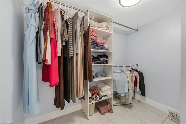 a view of walk in closet with clothes and shoes