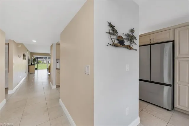 a view of hallway with furniture and a refrigerator