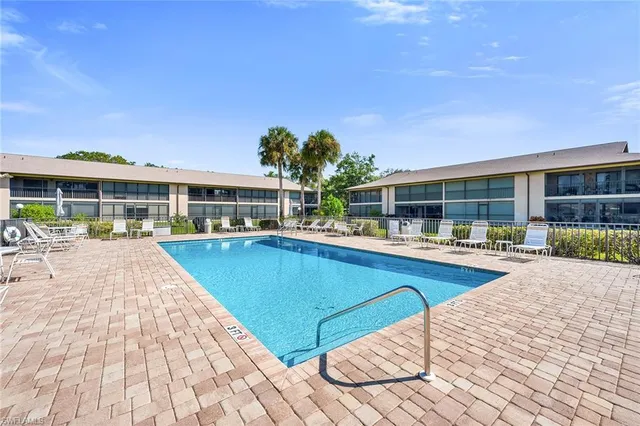 a view of a house with pool and chairs