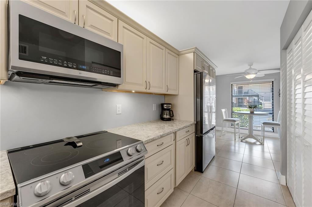 236 Pebble Beach Circle, Unit A102 Naples, FL 34113 - Photo 4 of 40 a kitchen with a stove and a microwave