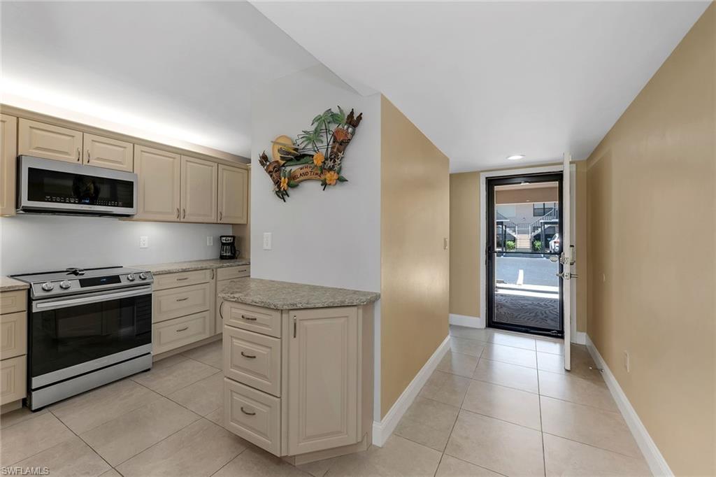 236 Pebble Beach Circle, Unit A102 Naples, FL 34113 - Photo 8 of 40 a kitchen with white cabinets and appliances