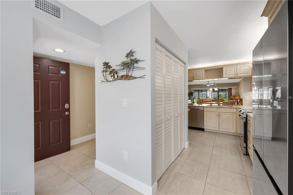236 Pebble Beach Circle, Unit A102 Naples, FL 34113 - Photo 9 of 40 a kitchen with white cabinets and white appliances