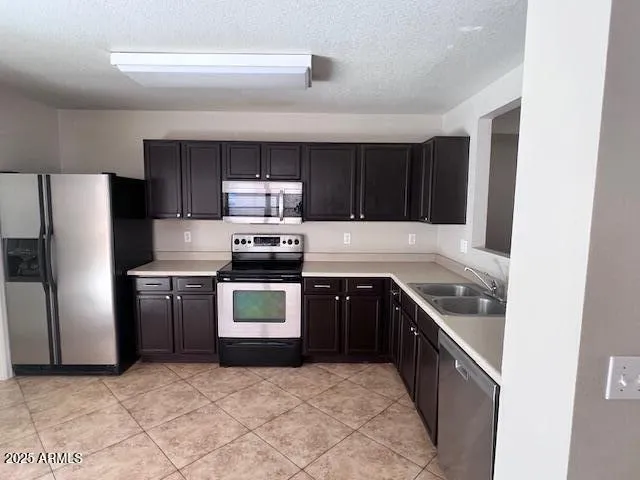 a kitchen with stainless steel appliances granite countertop a stove a refrigerator and a sink
