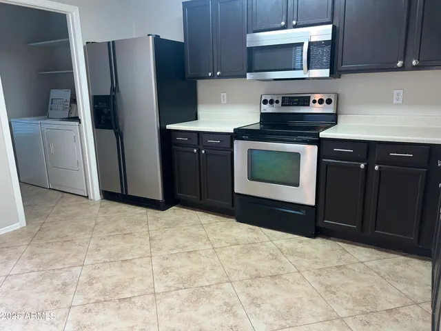 a kitchen with granite countertop a refrigerator and a stove top oven