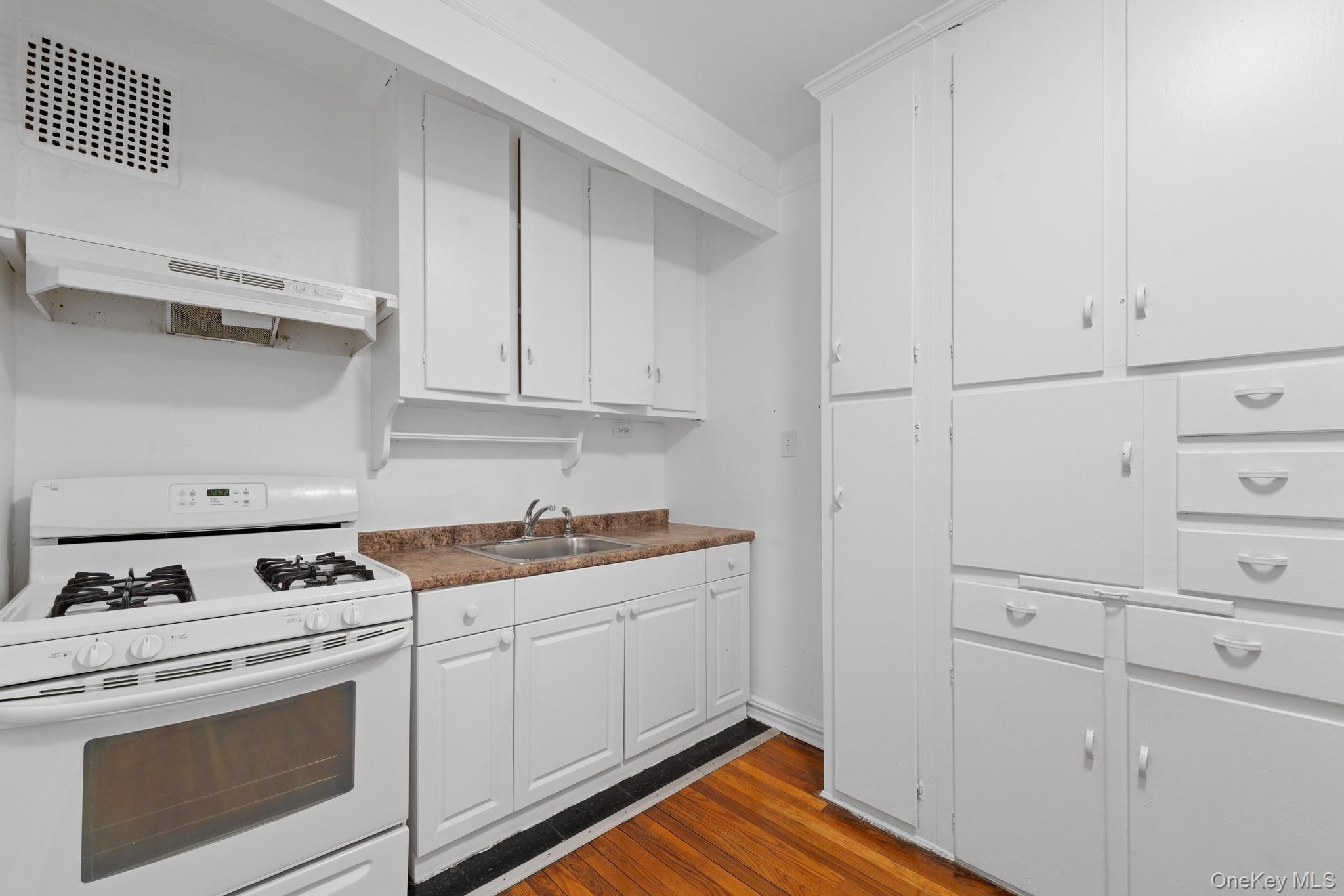 a kitchen with white cabinets and white appliances