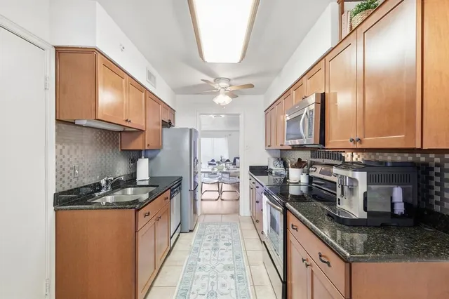 a kitchen with stainless steel appliances granite countertop a sink stove and cabinets