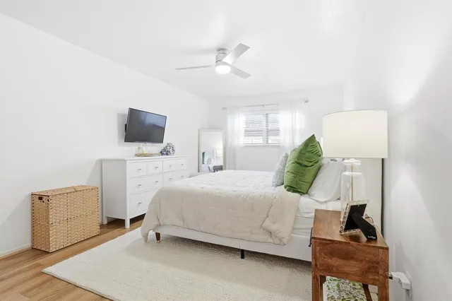 a bedroom with a bed and a flat tv screen on dresser