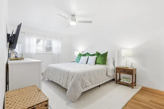 a bedroom with a bed a mirror on dresser and a window