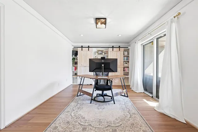 a work room with furniture a rug and a window