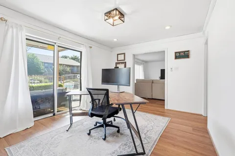 a workspace with wooden floor and a window