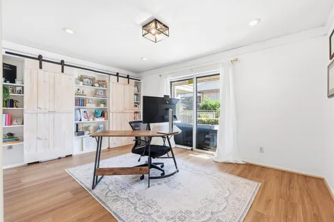 a view of a livingroom with workspace and a window