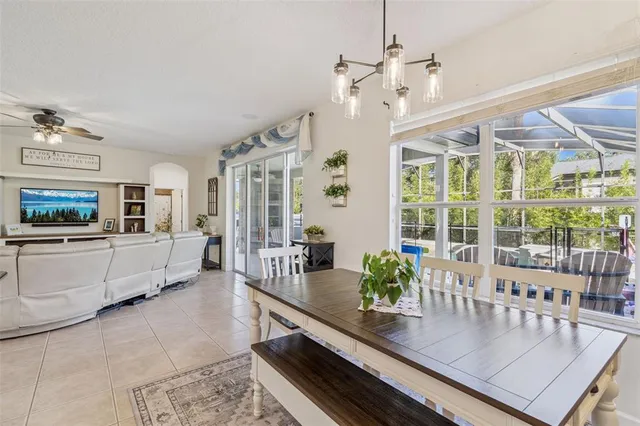 a dining room with furniture a chandelier and wooden floor