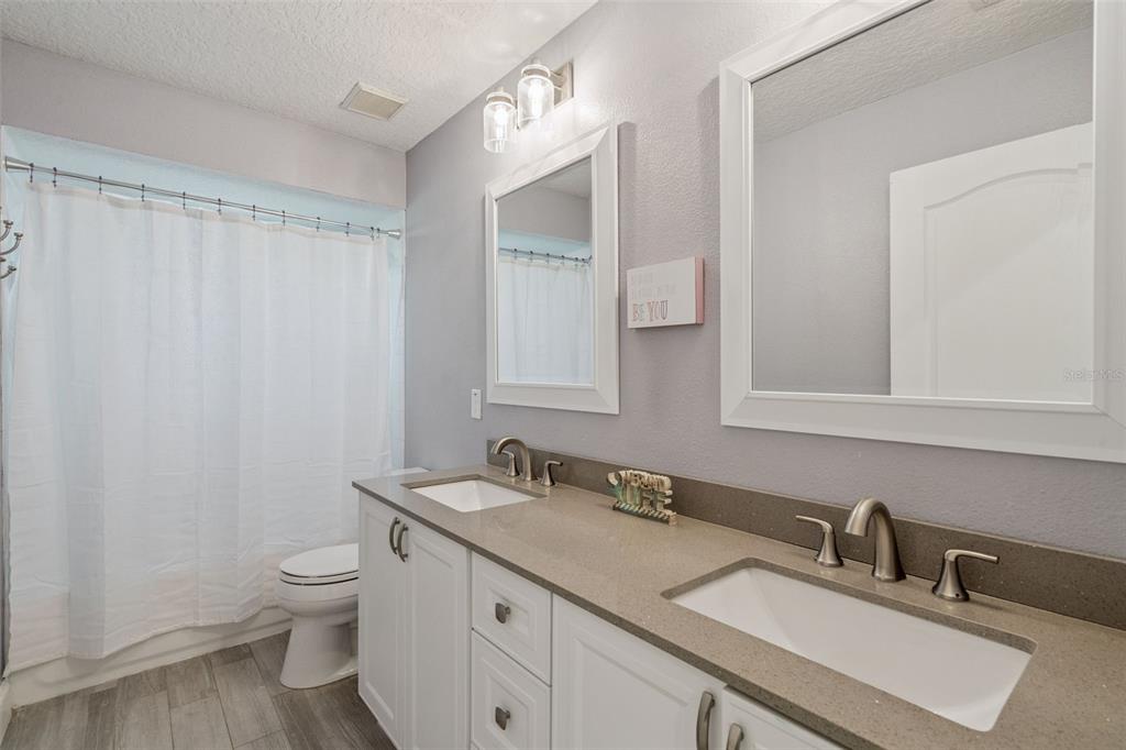 1471 Wescott Loop Winter Springs, FL 32708 - Photo 33 of 57 a bathroom with a granite countertop sink a toilet and a mirror