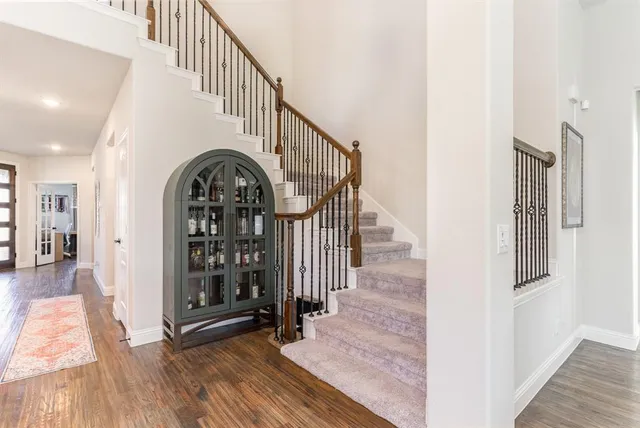 a view of staircase with wooden floor and a rug