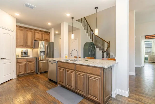 a kitchen with stainless steel appliances granite countertop a stove a sink and a refrigerator