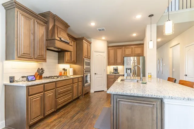 a kitchen with a sink refrigerator and cabinets