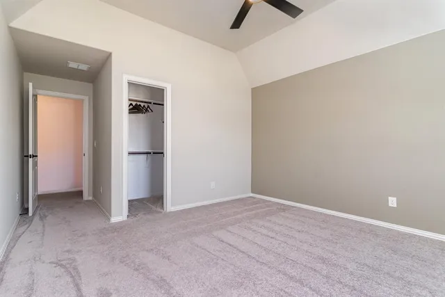 an empty room with windows and ceiling fan